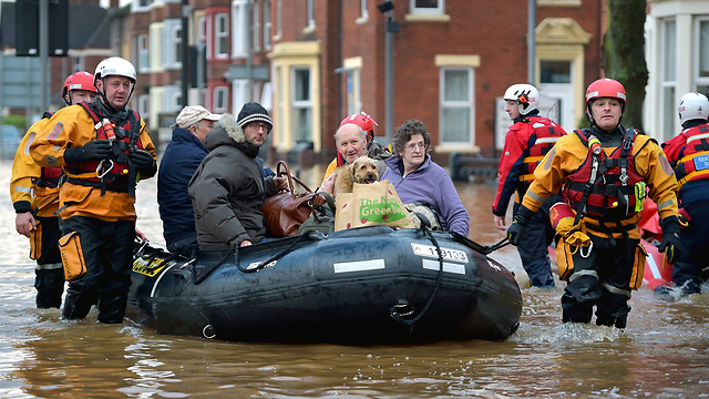 צוותי חילוץ והצלה מחלצים אנשים מבתים שהוצפו בסופה הקשה "דזמונד" בעיר קרלייל שבצפון אנגליה (צילום: gettyimages) (צילום: gettyimages)