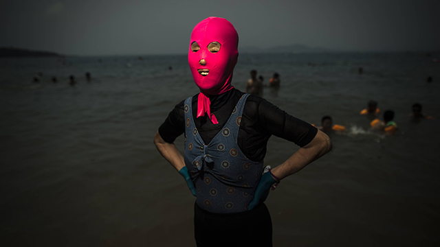 אישה לובשת "פייסקיני" - מסכה לפנים - בים בסין. מסכות לפנים הפכו בשנים האחרונות ללהיט בקרב הרוחצים בסין (צילום: AFP) (צילום: AFP)