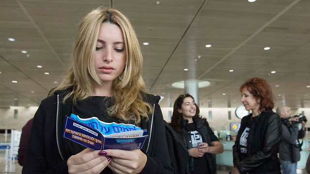 A traveler reading a new booklet on how to answer back to BDS claims (Photo: Ido Erez)