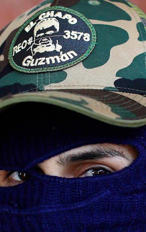בכובע של הרוצח - תמונתו של חואקים אל צ'אפו גוסמן, ראש קרטל הסמים "סינלואה" הנמלט (צילום: AP) (צילום: AP)
