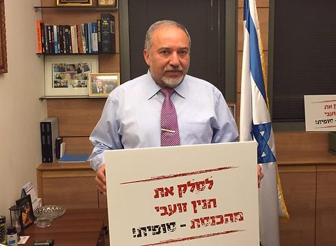 Lieberman holding a sign calling to 'Kick Haneen Zoabi from the Knesset - for good!'