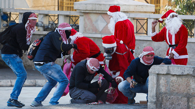 מתפרעים פלסטינים בתחפושת סנטה קלאוס ליד בית לחם (צילום: AP) (צילום: AP)