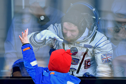 האסטרונאוט הבריטי טימותי פיק נפרד לשלום מילדיו לפני שיגורו במעבורת "סויוז" מקזחסטן לתחנת החלל הבינלאומית (צילום: רויטרס) (צילום: רויטרס)