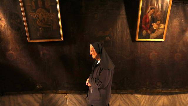 A Christian nun prays in the 'Grotto' of the Church of the Nativity (Photo: Reuters) 