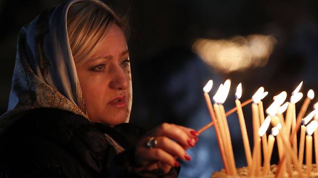 A Christian worshipper lights a candle at the Church of the Nativity (Photo: AFP)