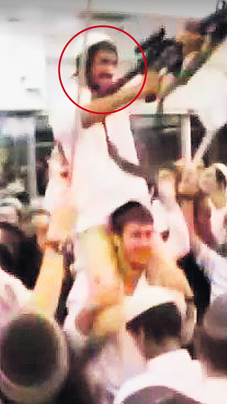 A participant in the 'wedding of hate' caught on film, who appears to be dancing with a gun in his hand