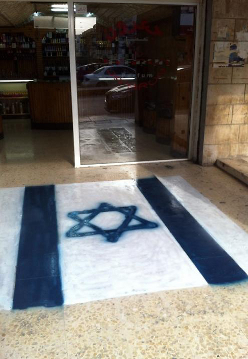 Israeli flag painted in front of a Jordanian shop so that clients can walk over it