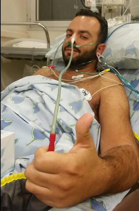 תמונת הניצחון: עידו לזן, שנפצע קשה בפיגוע בתל אביב, מודה לאנשי כוחות הביטחון לאחר חיסלו את המחבל. אחיו העלה את התמונה לפייסבוק ()