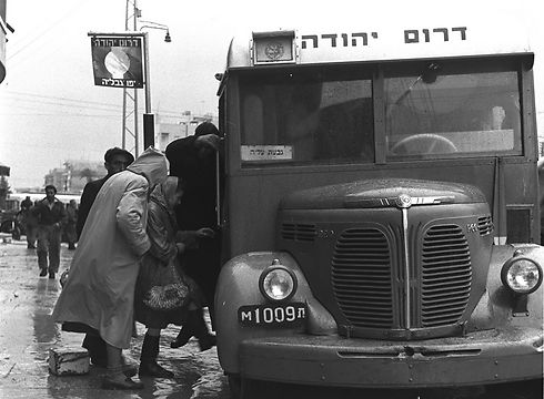 עולים לאוטובוס של חברת ״דרום יהודה״ בתחנת ג׳בליה שביפו בדרך לגבעת עליה ביום חורפי. תל אביב, 1949 (צילום: פריץ כהן, לע"מ) (צילום: פריץ כהן, לע