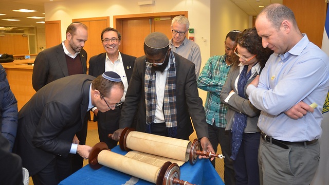 Members of an Ethiopian synagogue in Jerusalem receiving a donated 150-year-old Torah scroll (Photo: Courtesy)