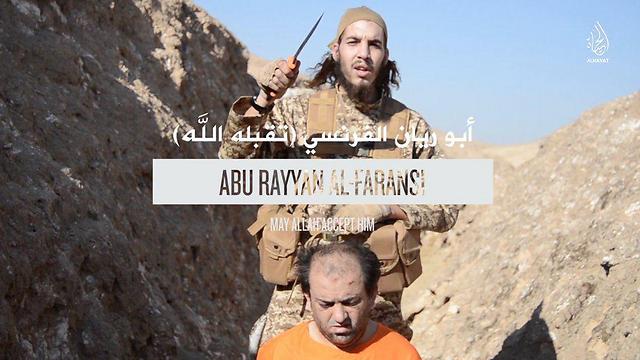 אחד המחבלים עומד לערוף את ראשו של מי שמוגדר "כופר" בסרטון של דאעש ()