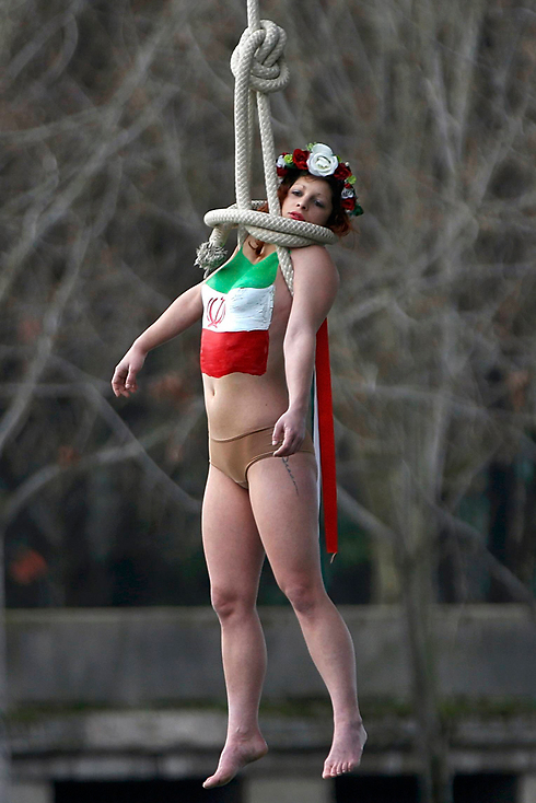 אשת Femen מפגינה נגד נשיא איראן חסן רוחאני בעת ביקורו בצרפת (צילום: רויטרס) (צילום: רויטרס)