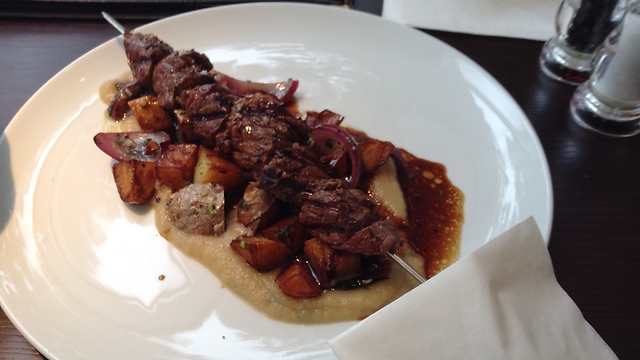 of beef filet on a bed of white onion cream, with crispy potato and charred red onion (Photo: Buzzy Gordon)