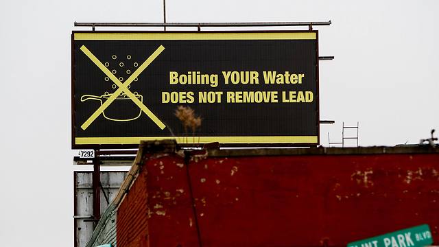 שלט המזהיר כי הרתחת המים אינה מטהרת מעופרת (צילום: AFP) (צילום: AFP)
