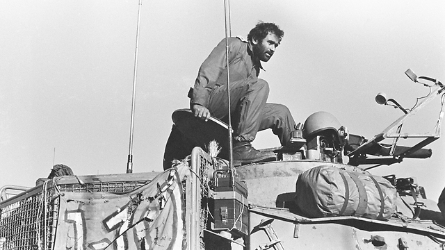 Avigdor Kahalni climbing out of a tank during the Yom Kippur War (Photo: Tom Hayman)