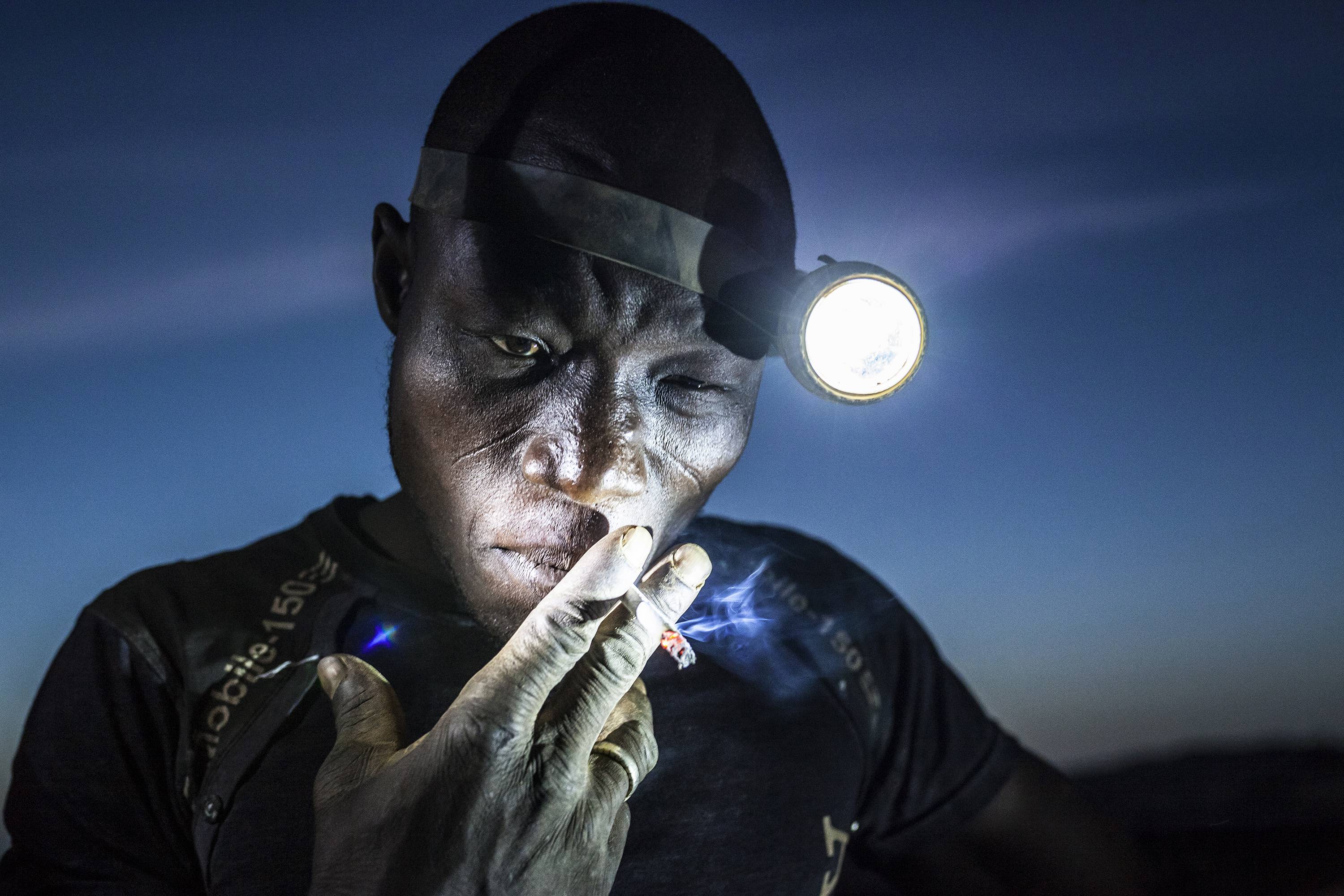 "כורים את העתיד", כורה מעשן בהפסקת עבודה בבורקינה פאסו (צילום: AP) (צילום: AP)