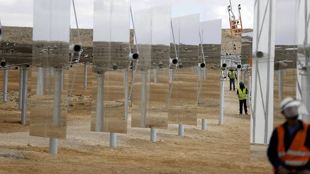 Construction workers install heliostat mirrors (Photo: Reuters)