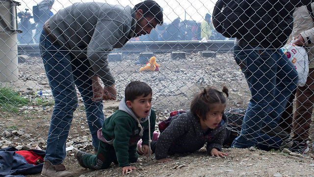 Children crawl under the boder fence from Greece into Macedonia (Photo: AP)
