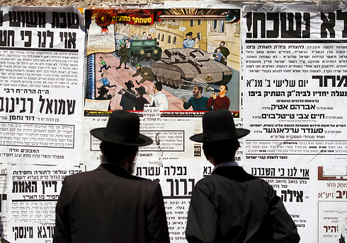 Haredi Jerusalemites view anti-ultra-Orthodox poster in Meah Sha'arim (Archive photo: EPA)