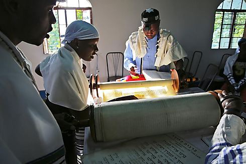 קהילת "אביודיה" באוגנדה: בתו של רב הקהילה, גרשון סיזומו, קוראת בתורה במהלך תפילת שחרית (צילום: דיוויד ג'ונו, Jono David) (צילום: דיוויד ג'ונו, Jono David)