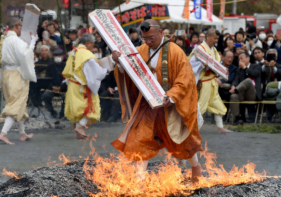 מאמין בודהיסטי הולך יחף על גחלים לוהטות בטקס "ללכת על האש" המבשר את בוא האביב בנגאטורו, יפן (צילום: AFP) (צילום: AFP)
