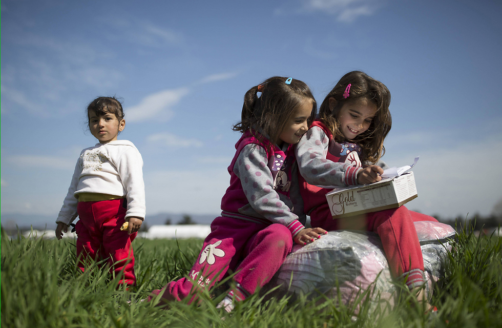 ילדים פליטים מסוריה משחקים בשדה בגבול יוון-מקדוניה בסמוך לעיירה היוונית אידומני (צילום: gettyimages) (צילום: gettyimages)