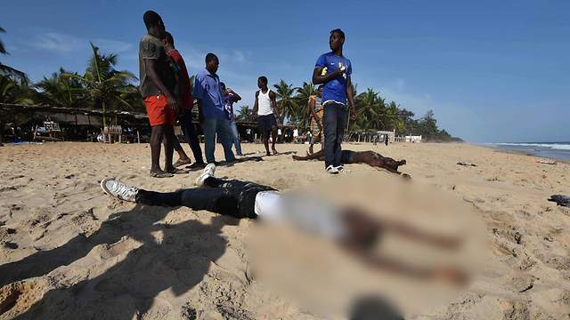 גופות נרצחים מוטלות בחול, אתמול בחוף בגראן-בסאם (צילום: AFP) (צילום: AFP)