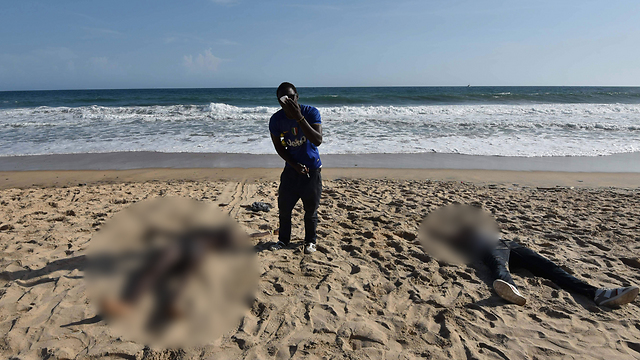 המחבלים פשטו על החוף עם קלצ'ניקובים ורימוני יד. גופות מוטלות בחול בחוף השנהב (צילום: AFP) (צילום: AFP)