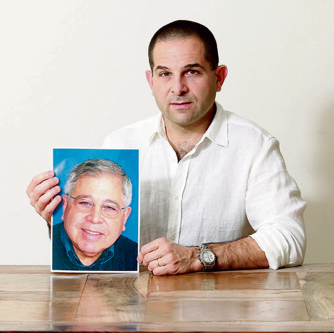 מיכה אבני, עם תמונת אביו ריצ'רד לייקין ז"ל | צילום: דנה קופל