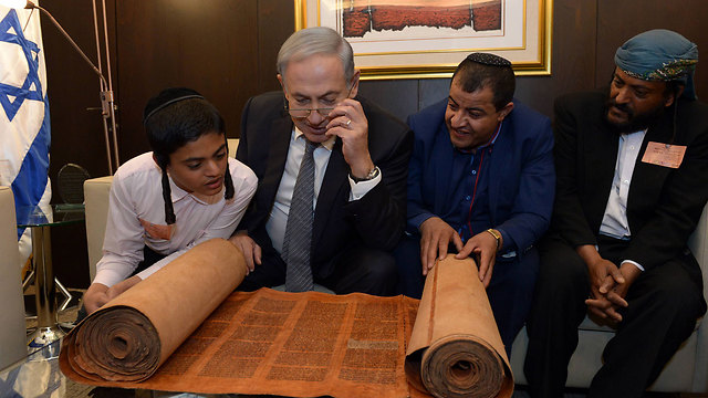 PM Netanyau with some of the group's members, and the antique torah scroll. (Photo: Haim Zach, GPO)