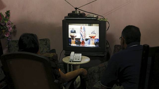 אזרחים קובנים צופים במסיבת העיתונאים הלא-שגרתית מבחינתם (צלום: רויטרס) (צלום: רויטרס)