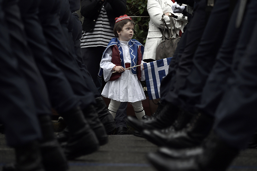 ילד לבוש במדי המשמר הנשיאותי היווני במהלך מצעד צבאי במרכז אתונה לרגל חגיגות יום העצמאות (צילום: AFP) (צילום: AFP)
