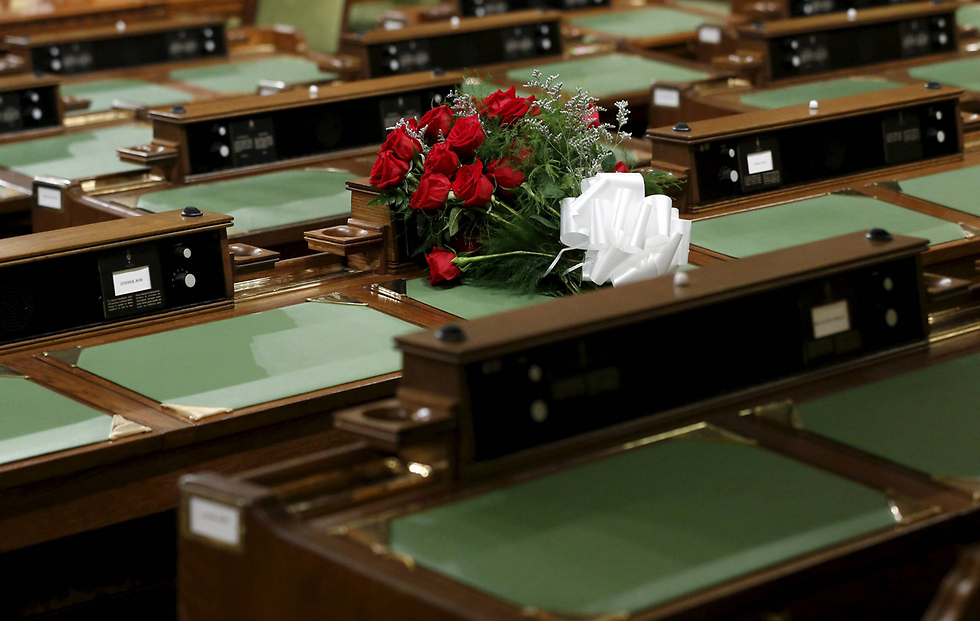 פרחים מונחים ליד מושבו של המחוקק הקנדי המנוח ג'ים הילייר, שנמצא מת במשרדו, בפרלמנט באוטווה (צילום: רויטרס) (צילום: רויטרס)