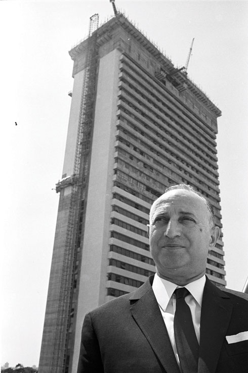 הסבא משה מאייר על רקע מגדל שלום הנבנה, 1965 (צילום: דוד רובינגר)