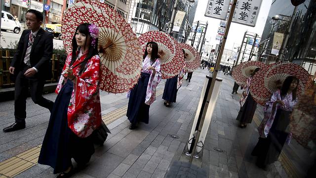 נשים בקימונו צועדות עם מטרייה במרכז הקניות גינזה שבטוקיו (צילום: רויטרס) (צילום: רויטרס)