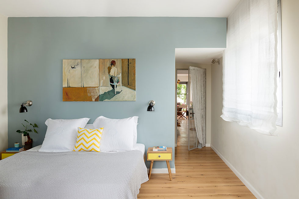 הקיר שעליו נשענת המיטה נצבע בתכלת, וגם עליו תלוי ציור של פסו (צילום: גדעון לוין)