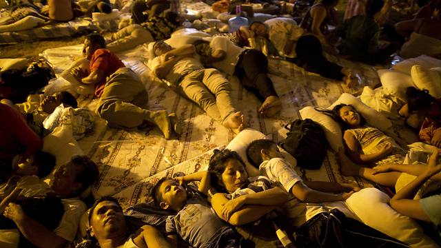 אלפים ישנים ברחוב, מחובקים לצד שכניהם (צילום: AP) (צילום: AP)