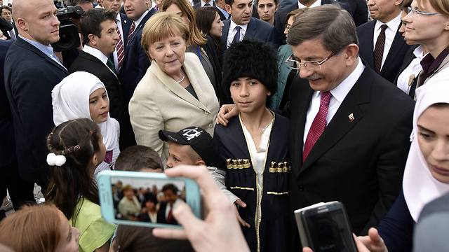 דבוטאולו ומרקל במפגש עם פליטים בטורקיה (צילום: Getty Images) (צילום: Getty Images)
