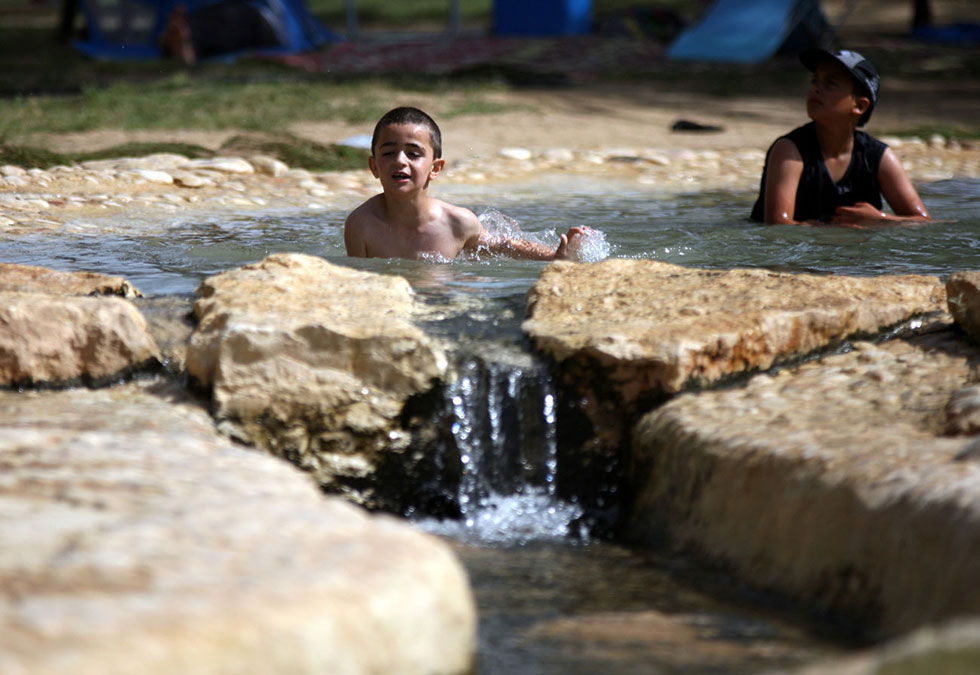 Children escape the hot weather and enjoy the cool water at the Eshkol Park (Photo: Roee Idan)