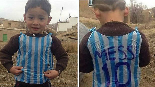 הילד בן החמש מאפגניסטן וחולצת מסי מניילון שהכין בעצמו ()