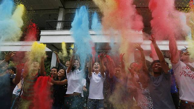 לווי פו, אחותה של המועמדת לנשיאות הפיליפינים גרייס פו, משליכה אבקה צבעונית במנילה ביחד עם אנשים רבים נוספים לאחר שגרייס זכתה לתמיכת ארגון הצעירים "קבטאן" (צילום: AP) (צילום: AP)