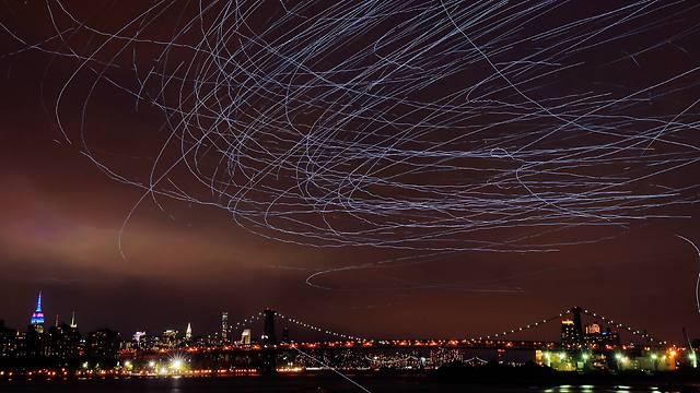 מיצג אמנותי מעל שמי ניו יורק - שובל אור שהותירו אחריהן יונים שאליהן הוצמדו נורות LED (צילום: רויטרס) (צילום: רויטרס)