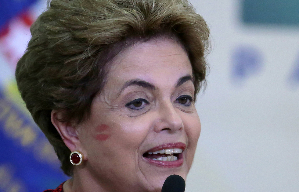 סימן של נשיקה נותר על לחייה של נשיאת ברזיל דילמה רוסף במהלך הכרזה על פתיחת אוניברסיטאות חדשות בברזיליה (צילום: AP) (צילום: AP)