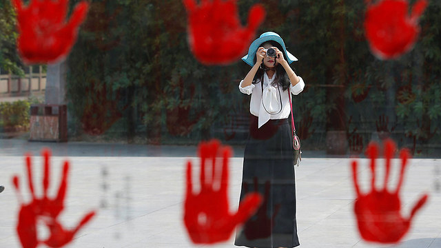 מבקרת צופה בטביעות יד של גיבורי מלחמת ההתנגדות ליפן במוזיאון במחוז הסיני סצ'ואן (צילום: רויטרס) (צילום: רויטרס)