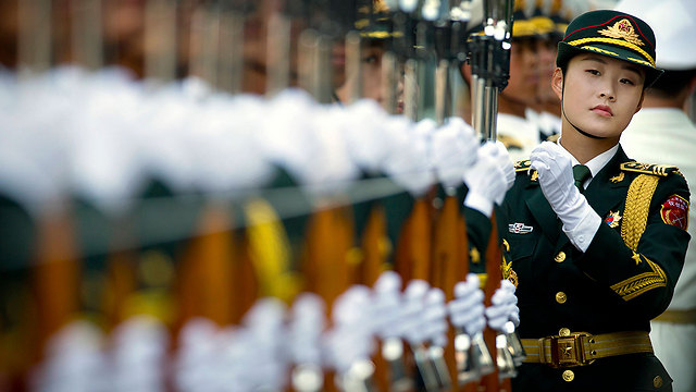 קצינת צבא בוחנת את משמר הכבוד לפני טקס קבלת פנים בבייג'ינג לנשיא מוזמביק פיליפ ג'אקינטו ניוסי (צילום: AP) (צילום: AP)
