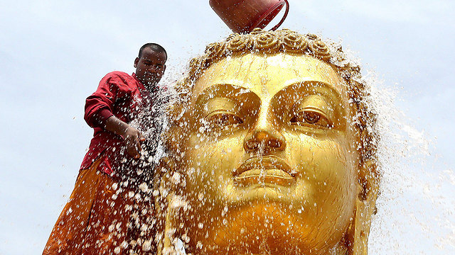 נזיר בודהיסיטי מנקה את פסל הבודהה במנזר בעיר ההודית בופאל לרגל חגיגות יום הולדת 2,560 למנהיג הרוחני (צילום: EPA) (צילום: EPA)