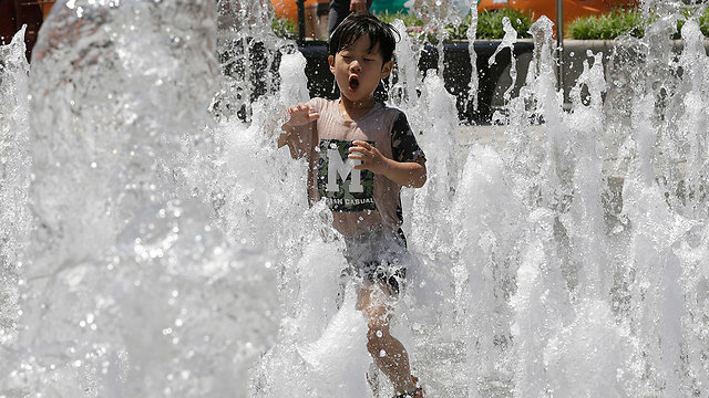 ילדים משחקים במזרקת מים בסיאול, בירת דרום קוריאה, בחום הכבד (צילום: AP) (צילום: AP)