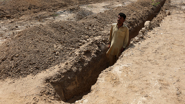 חפר שלוש תעלות מוארכות שיוכלו להכיל 300 גופות. חופר הקברים שאהיד באלוץ' מקראצ'י (צילום: רויטרס) (צילום: רויטרס)