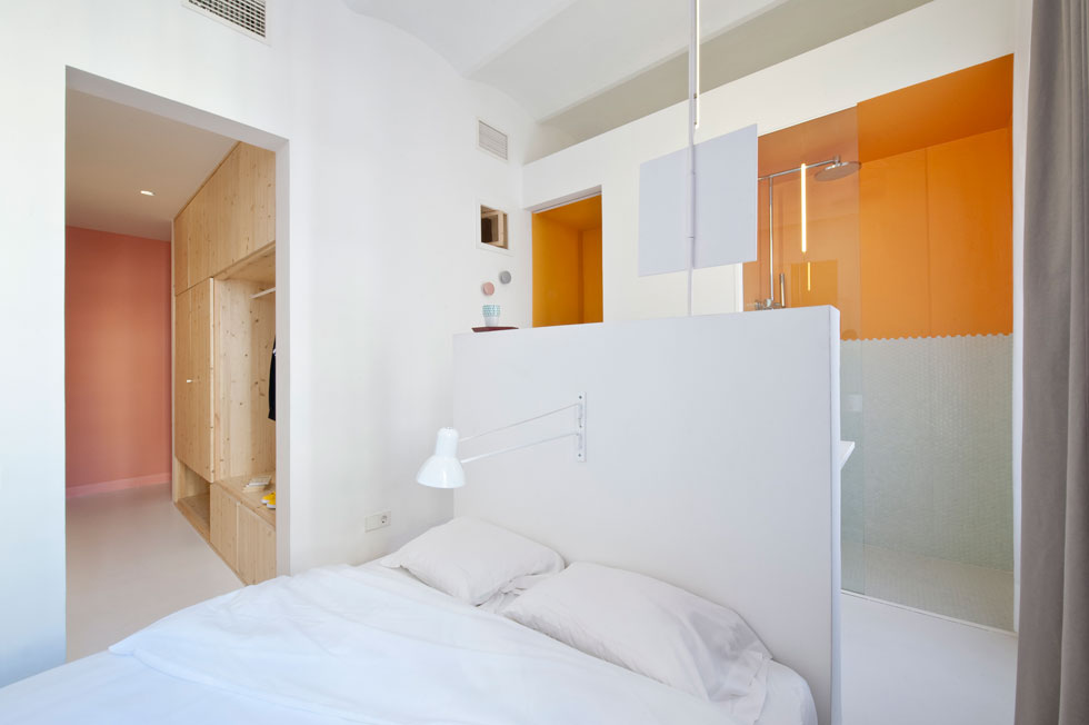 הנה ניצול חכם של המרחב: קיר נמוך משמש כגב המיטה מצד אחד, ומהצד השני תומך בכיור בחדר הרחצה. שתי קוביות עץ נמוכות משמשות כשידות, כמו גם כמדרגות ומעבר לחדר הרחצה. הקיר הנמוך מבטיח שאור השמש יחדור גם לחדר הרחצה (צילום: Roberto Ruiz)