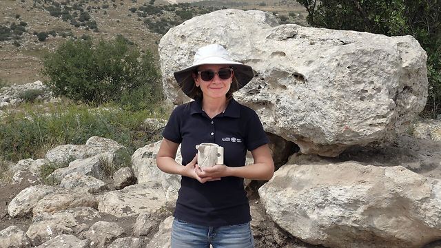 ארכיאולוגית רשות העתיקות, ג'ני מרכוס, מחזיקה ספל אבן מימי הבית השני שהתגלה בבית האחוזה (צילום: אברהם טנדלר) (צילום: אברהם טנדלר)